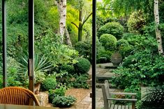 an outdoor patio with wooden chairs and trees