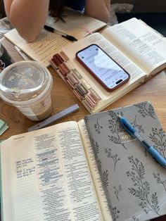 an open book sitting on top of a wooden table next to a cup of coffee