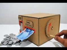 a cardboard box that has some money coming out of it and is open to reveal the inside