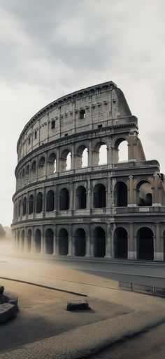 an old roman colliseum in the middle of a foggy day with no people around