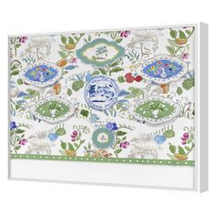 a white wall hanging with blue and green designs on it