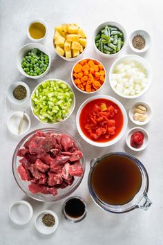 the ingredients for this meal include meat, vegetables, and sauces in small bowls