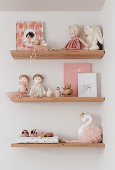 two wooden shelves filled with toys on top of a white wall next to other items