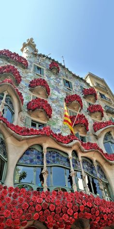 an elaborate building with red flowers on the windows