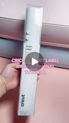 a person is holding up a white tube in front of a pink box with the words cricut's art label written on it