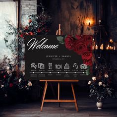 a welcome sign with red roses on it in front of some candles and other flowers