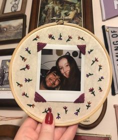 a person holding up an embroidered photo frame