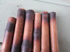 five wooden pipes lined up next to each other on the floor in front of a door