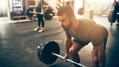 a man lifting a barbell in a gym