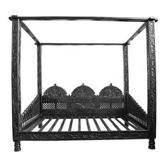 an antique black iron bed frame with intricate carvings