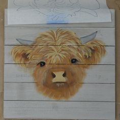 a wooden sign with a painting of a bison on it's face and horns