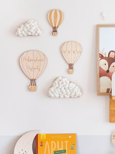 wooden hot air balloons are mounted on the wall above a bookcase and other toys