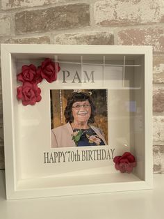 a photo frame with flowers on it and a happy 70th birthday message