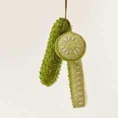 an ornament hanging from a string with green beads