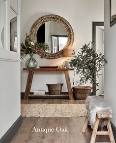 a wooden bench sitting under a round mirror next to a potted plant on top of a table