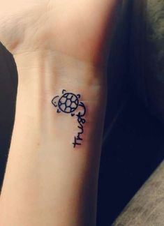 a small tattoo on the wrist of a person with a turtle in it's shell