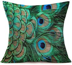 a green pillow with peacock feathers on it