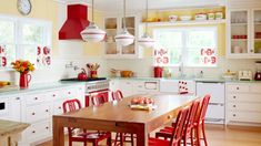 a kitchen filled with lots of red chairs next to a wooden table and counter top