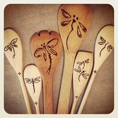 six wooden spoons with dragonfly designs on them