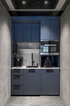 a modern kitchen with blue cabinets and marble counter tops is seen in this image from the doorway