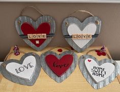 four heart shaped wooden signs hanging on a wall