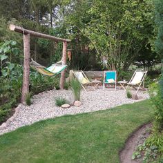 an outdoor area with hammock, chairs and trees in the back yard on a sunny day