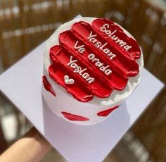 a close up of a cake on a table with red icing and writing in spanish