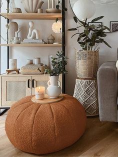 a living room filled with lots of furniture and plants on top of a wooden table