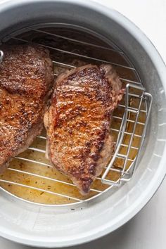 two steaks are cooking in an air fryer