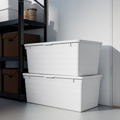 two white storage containers sitting next to each other in a room with shelving and shelves