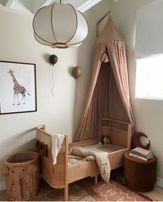 a child's bedroom with a canopy bed and giraffe artwork on the wall