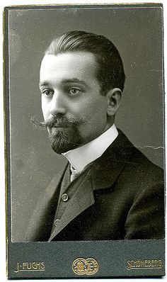 an old black and white photo of a man in a suit with a moustache