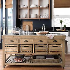 a kitchen island made out of wooden crates with drawers and baskets on the bottom shelf