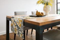 a dining room table with two pears on it and a vase full of flowers