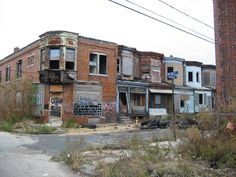 an old run down building with lots of windows and graffiti on the side of it