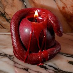 a red candle sitting on top of a marble counter