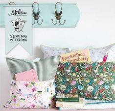 several pillows are stacked on top of each other in front of the sewing pattern shop sign