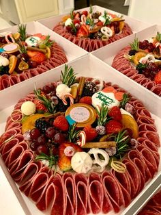 four square trays filled with different types of food on top of a table next to each other