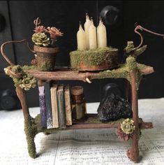 a table with books, candles and plants on it