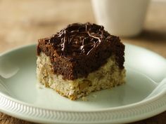 a piece of cake sitting on top of a blue plate next to a white cup