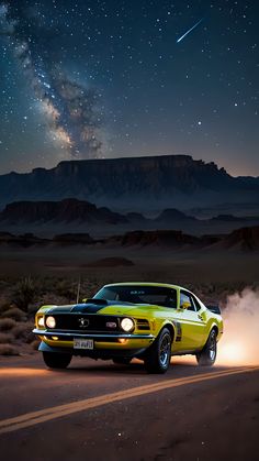 a yellow mustang driving down a desert road at night