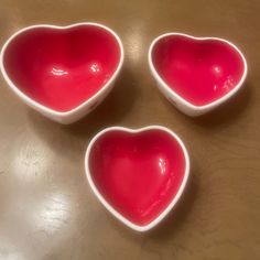 three heart shaped bowls sitting on top of a table