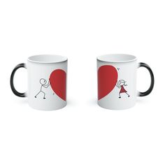 two black and white coffee mugs with stick figures holding hands in front of a red heart