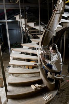 a woman sitting on top of a wooden staircase