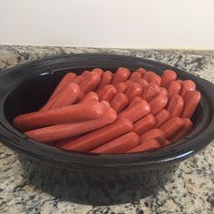 carrots are in a black bowl on the counter