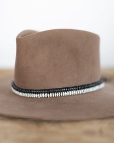 Hat band with Ceramic Disc Beads and Brass Accent Beads. Material: Ceramic Disc Beads, Brass Beads Dimensions: 21" Beaded Length Closure: Adjustable Slide Closure to fit any hat Handmade by Crossbow in the mountains of Telluride, CO.