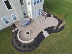 an aerial view of a house with a patio and fire pit in the front yard