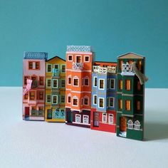 a group of colorful buildings sitting on top of a white table next to each other