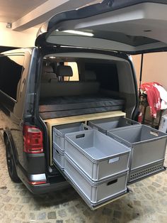 the back end of a black van with two storage bins