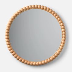 a round mirror with wooden beads around it